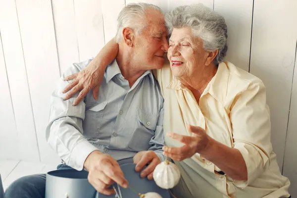 Elegant old couple sitting at home with christmas gifts — Stock Photo, Image