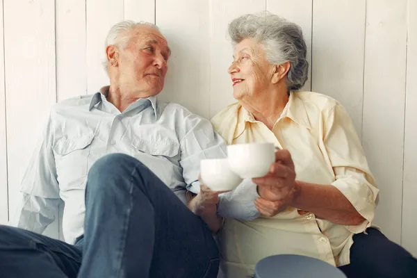 Elegant old couple sitting at home on a foor — Stock Photo, Image