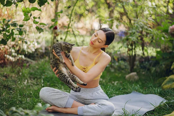 Dziewczyna siedzi w letnim parku z cute cat — Zdjęcie stockowe