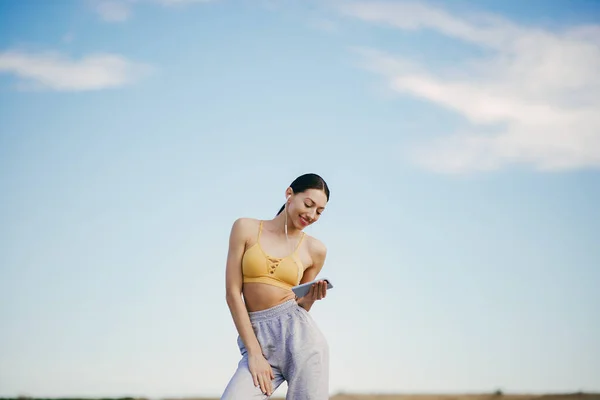 Carino ragazza con telefono formazione su un cielo backgroung — Foto Stock