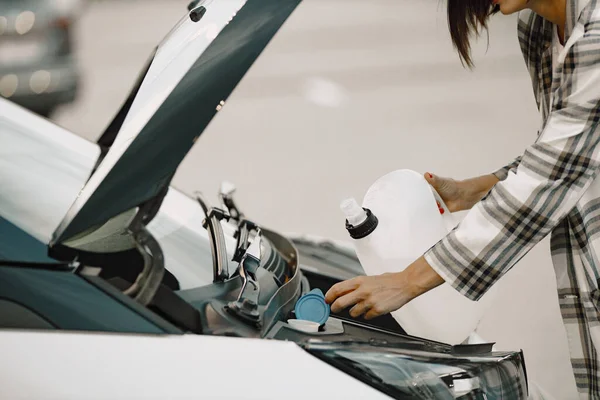 Foto ritagliata di donne mani versando un po 'di liquido nel suo motore auto — Foto Stock