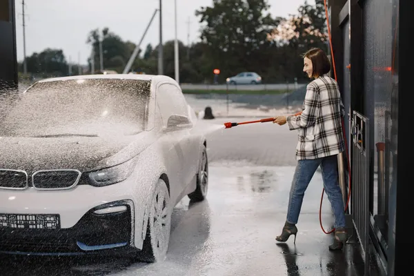 Wanita mencuci mobilnya di stasiun cuci mobil — Stok Foto