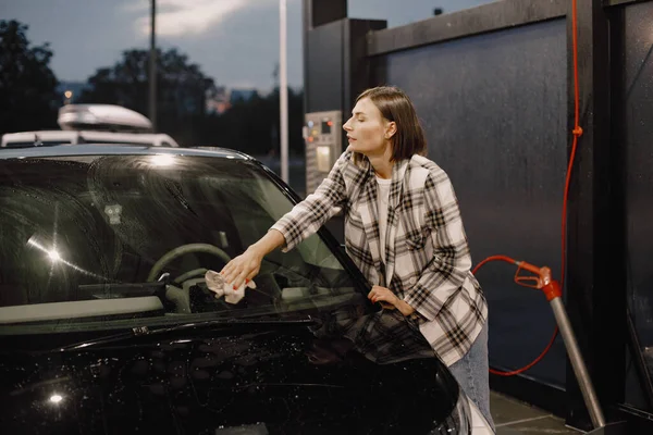 Mujer lavando su coche con una alfombra en la estación de lavado de coches — Foto de Stock