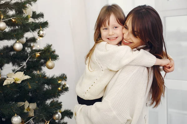 Madre con linda hija de pie cerca del árbol de Navidad — Foto de Stock