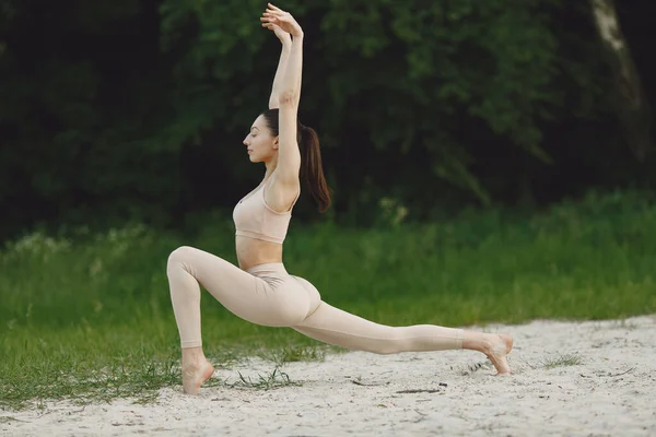 Femme pratiquant le yoga avancé dans une plage — Photo