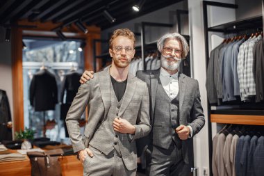 Üst düzey bir adam mağazadan yeni bir takım elbise seçiyor.