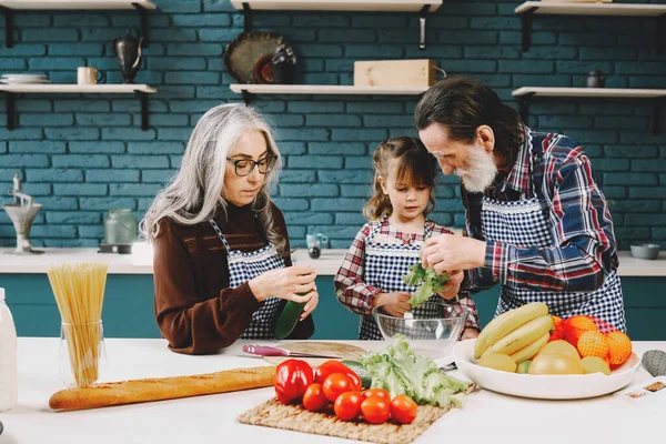 Anziani nonni coppia con nipote cucina in cucina — Foto Stock