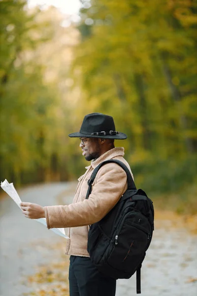 Чорний чоловік стоїть на дорозі і тримає карту — стокове фото