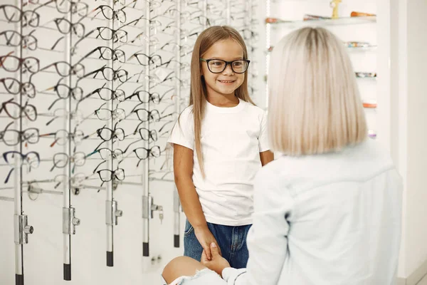 Family choosing glasses at optics store — Stockfoto