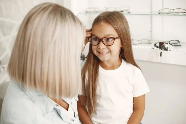 Family choosing glasses at optics store — стоковое фото