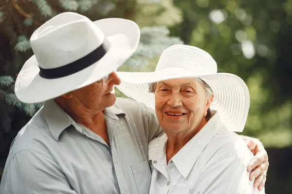 Beautiful old couple spend time in a summer garden — Stock Photo, Image