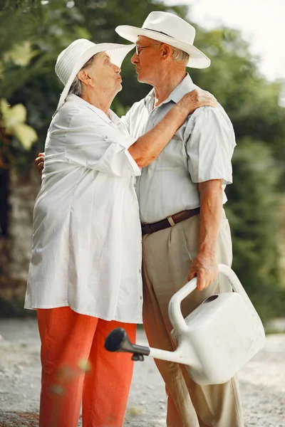 Beautiful old couple spend time in a summer garden — Stock Photo, Image