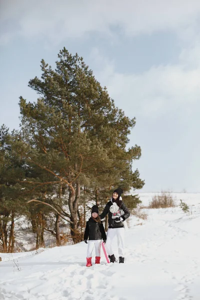 Mère et enfant en vêtements d'hiver jouent dans le parc d'hiver — Photo