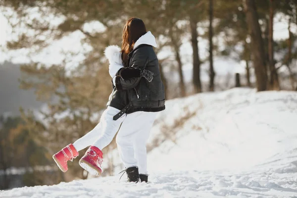 Mère et enfant en vêtements d'hiver jouent dans le parc d'hiver — Photo