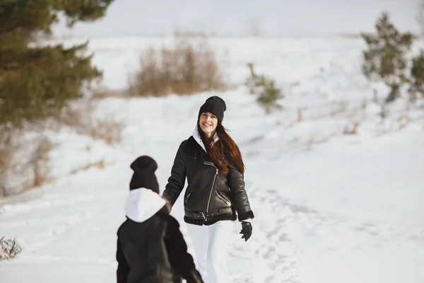 Mère et enfant en vêtements d'hiver jouent dans le parc d'hiver — Photo