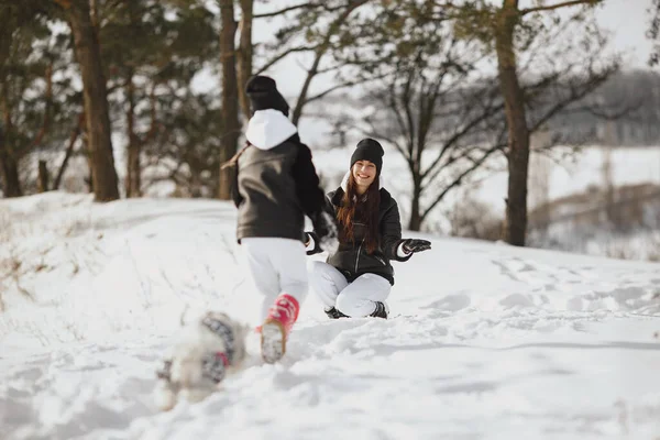 Mutter und Kind in Winterkleidung spielen im Winterpark — Stockfoto