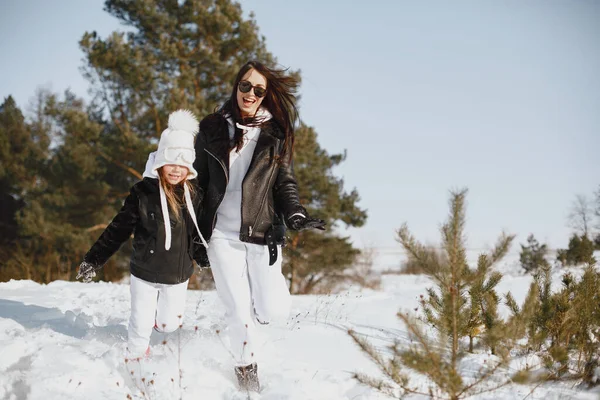 Mãe e criança em roupas de inverno brincam no parque de inverno — Fotografia de Stock