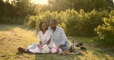 Black young couple on a summer picnic on meadow
