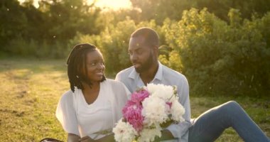 Black couple with flowers on a summer picnic