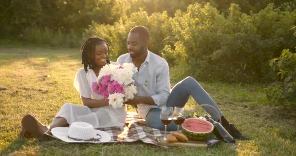 Black couple with flowers on a summer picnic — ストック動画