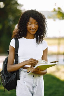 Female african student posing looking at camera standing in a park