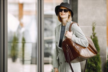 Portrait of a fashionable model with big brown bag outdoors