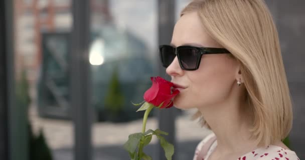 Close-up of young woman smelling rose at city — Vídeo de Stock