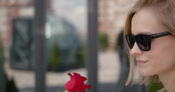 Close-up of young woman smelling rose at city — 图库视频影像