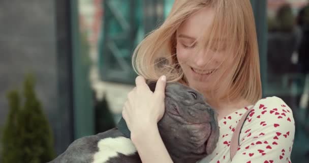 Beautiful young girl holding adorable French bulldog puppy — Stock video