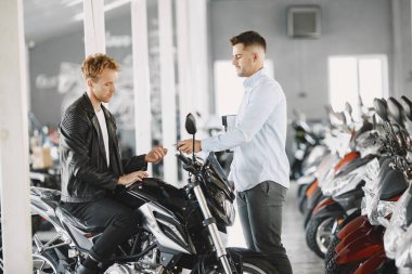 Motosiklet almayı seçen yakışıklı bir adam.