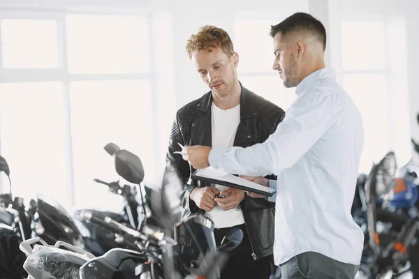 Schöner Mann wählt ein Motorrad zu kaufen — Stockfoto