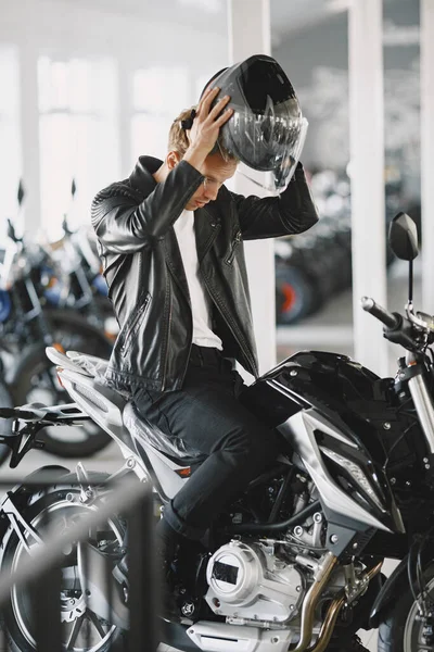 Handsome man choosing a motorcycle to buy — Stock Photo, Image