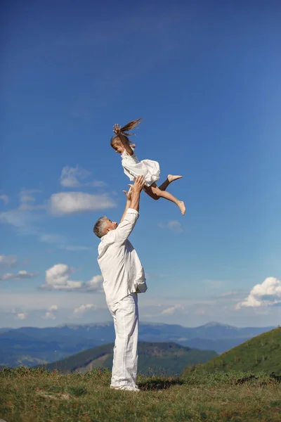 Padre jugando con la pequeña hija en una montaña —  Fotos de Stock