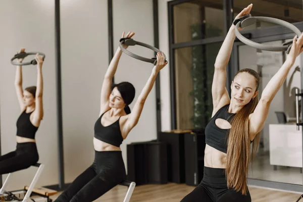 Three girls in a bright gym doing functional training with equipment — Stockfoto