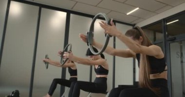 Three women performing exercise on a reformer bed