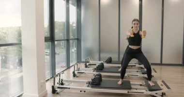 Three women doing pilates on a reformer bed