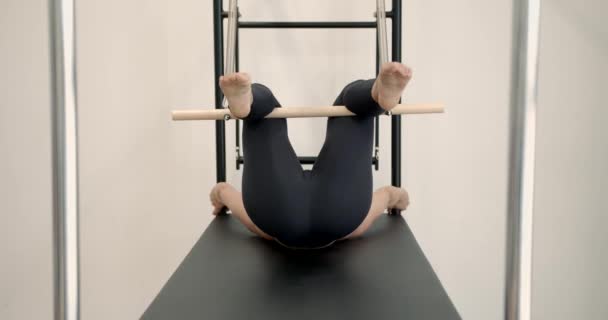 Beautiful woman doing pilates exercise on machine — Stock Video