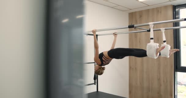 Young girl doing pilates exercises with a reformer bed — Vídeo de Stock