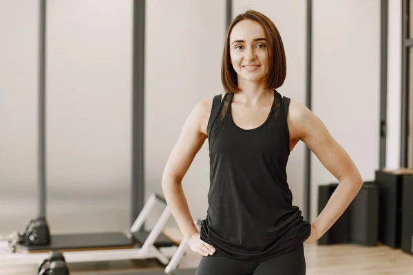 Young woman in a gym looking in a camera and smiling — Stockfoto