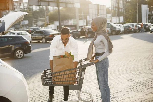 Africano arabo coppia pack alimentari in un auto — Foto Stock