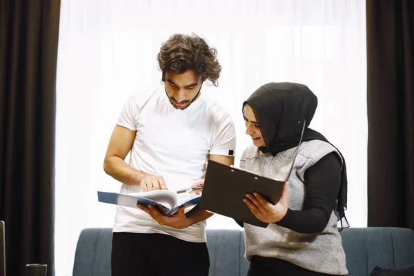Młodzi studenci, para arabska przygotowująca się do egzaminów we wnętrzu mieszkania — Zdjęcie stockowe
