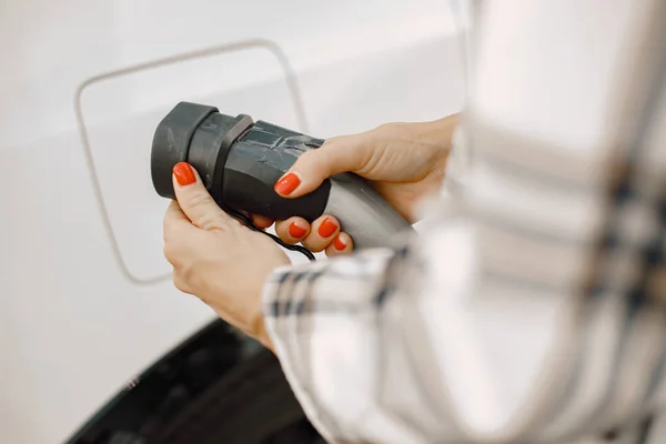 Cropped photo of plug for charging an electrocar and womans hands — Foto Stock