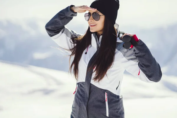 Молодые и активные брюнетки катаются на лыжах в заснеженных горах — стоковое фото
