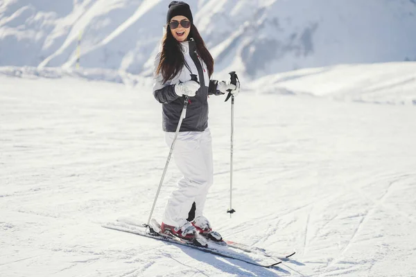Junge und aktive Brünette beim Skifahren in den verschneiten Bergen — Stockfoto