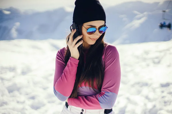 Junge und aktive Brünette beim Skifahren in den verschneiten Bergen — Stockfoto