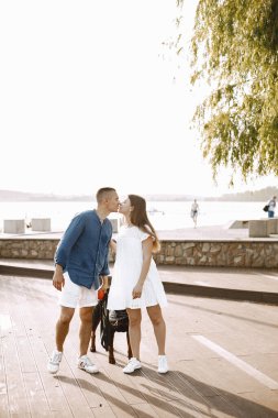 Portrait of a romantic couple with their rotweiller near the lake