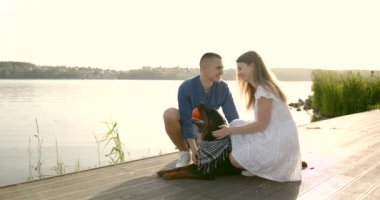 Loving young couple with a dog by lake