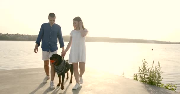 Young European couple going near lake with dog — Stok video