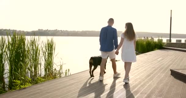 Young European couple going near lake with dog — kuvapankkivideo