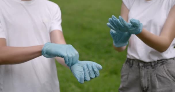 Sukarelawan muda memakai sarung tangan karet di luar ruangan. — Stok Video